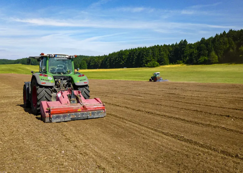 Traktor mit Steinzerkleinerer auf einem Acker