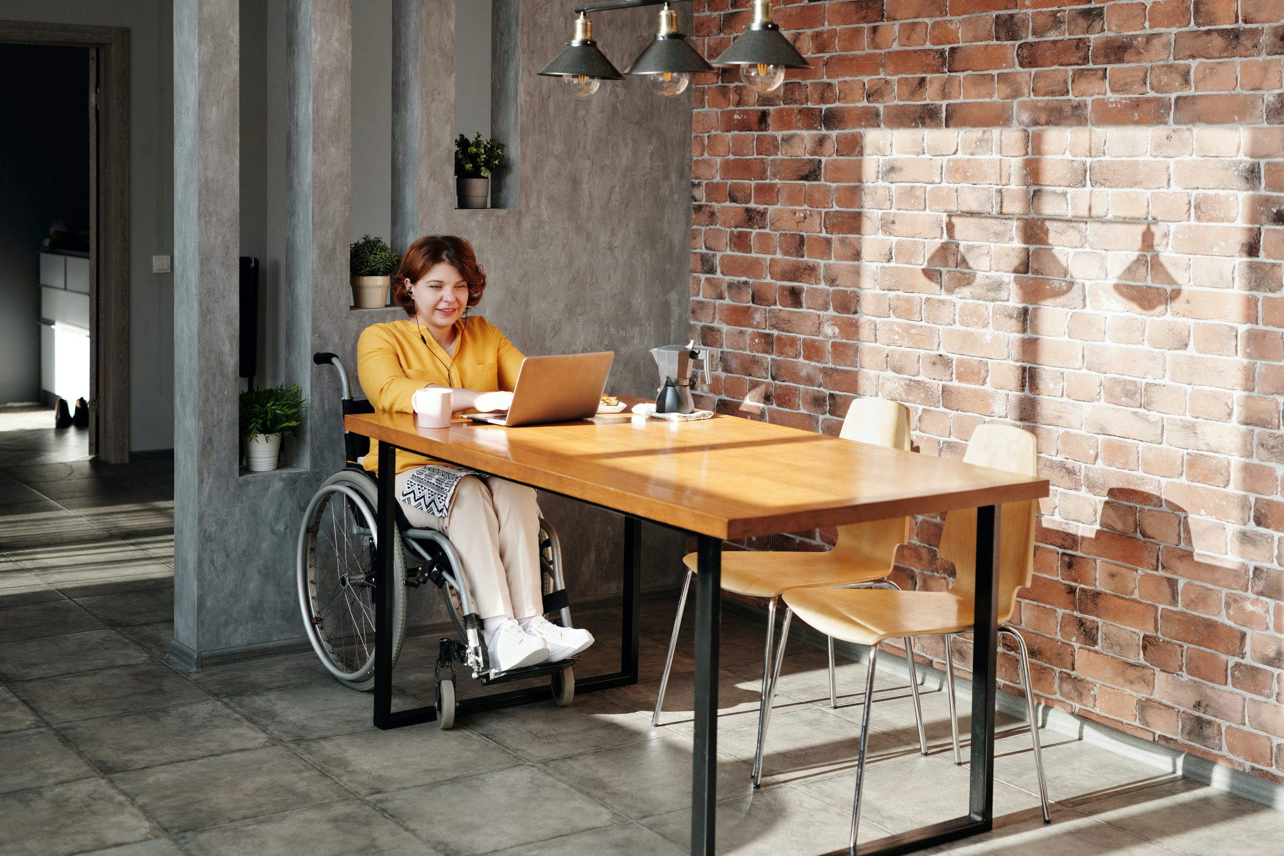 Une personne en fauteuil roulant utilise un ordinateur portable