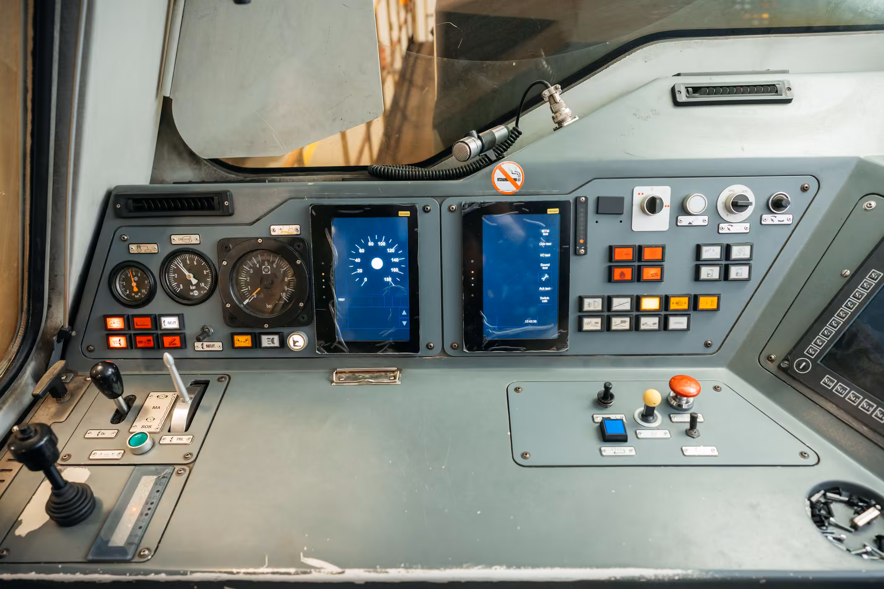 Train cab desk fitted with two blue ETCS driver display screens.