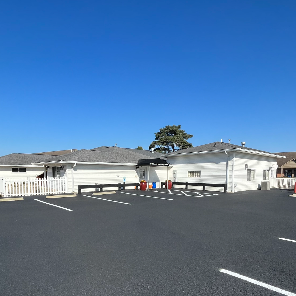 Newly striped and sealcoated parking lot in front of a single-story commercial building