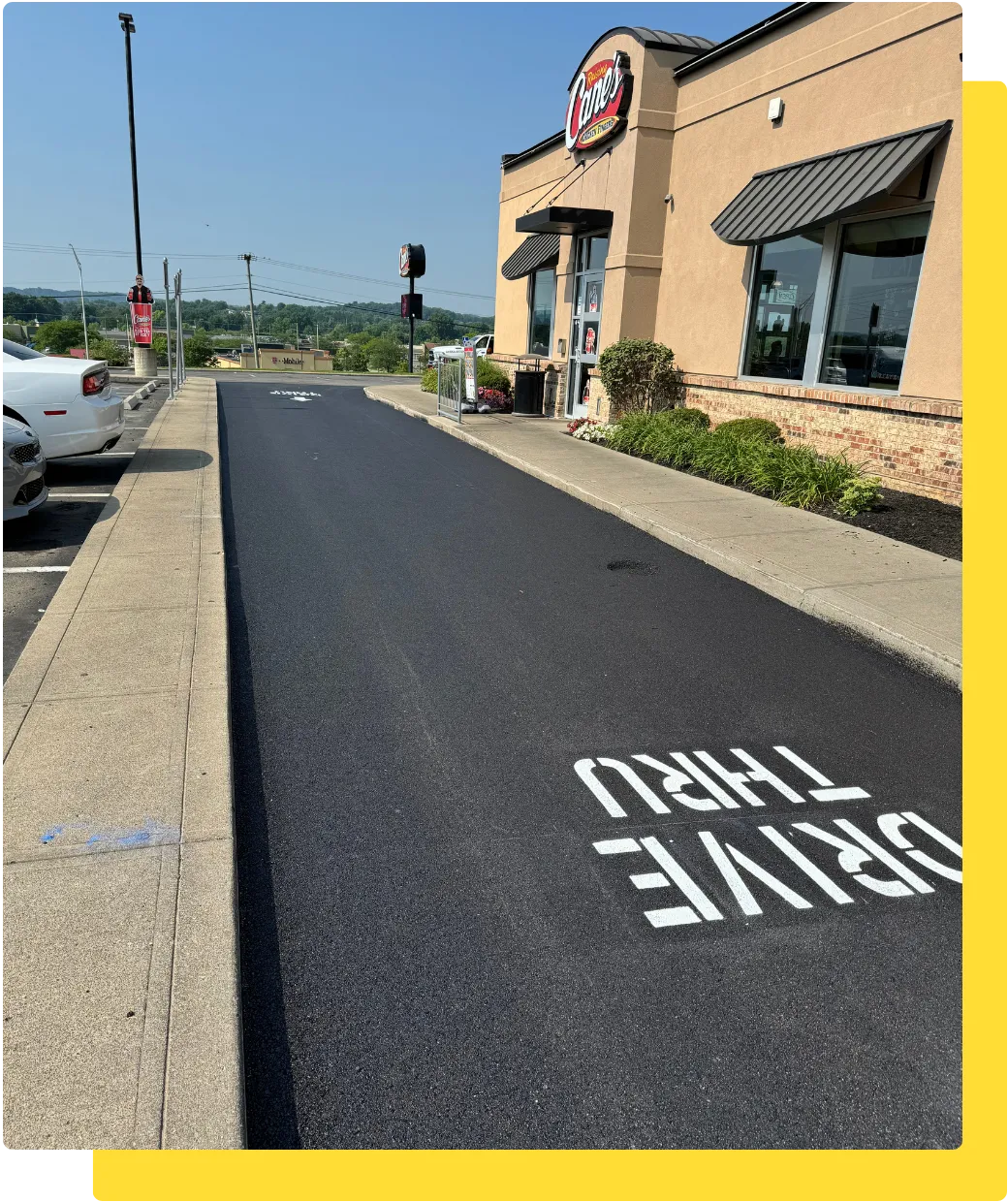 Freshly sealcoated restaurant drive-thru lane with new "DRIVE THRU" pavement lettering