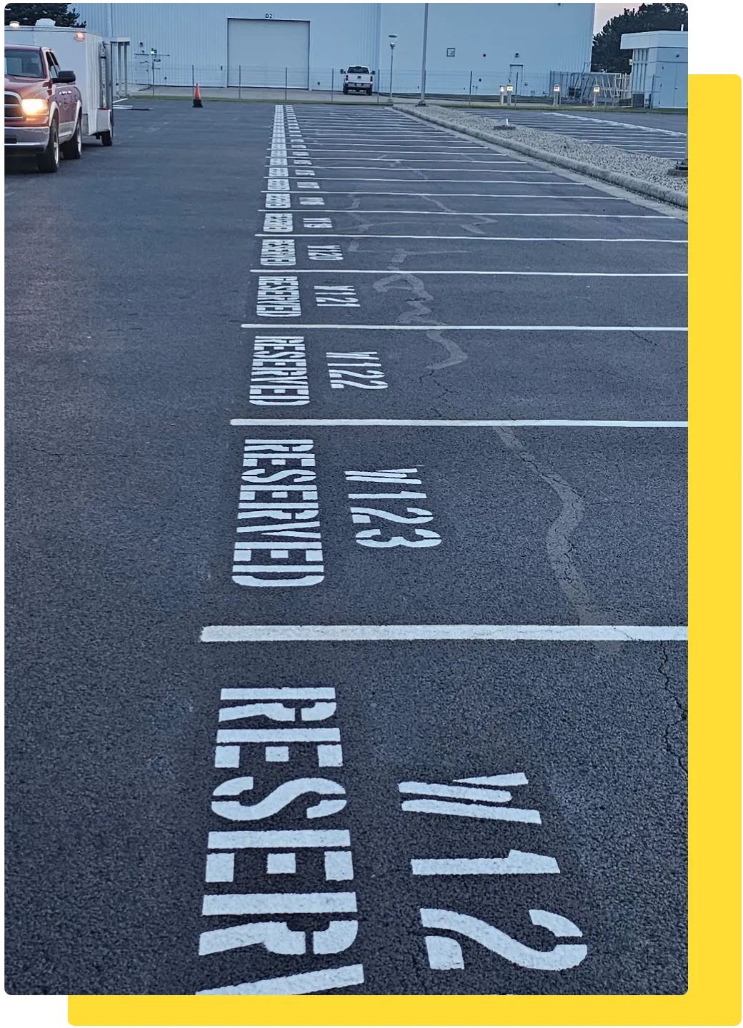 Freshly painted reserved parking stall numbers and lines on a sealcoated commercial lot