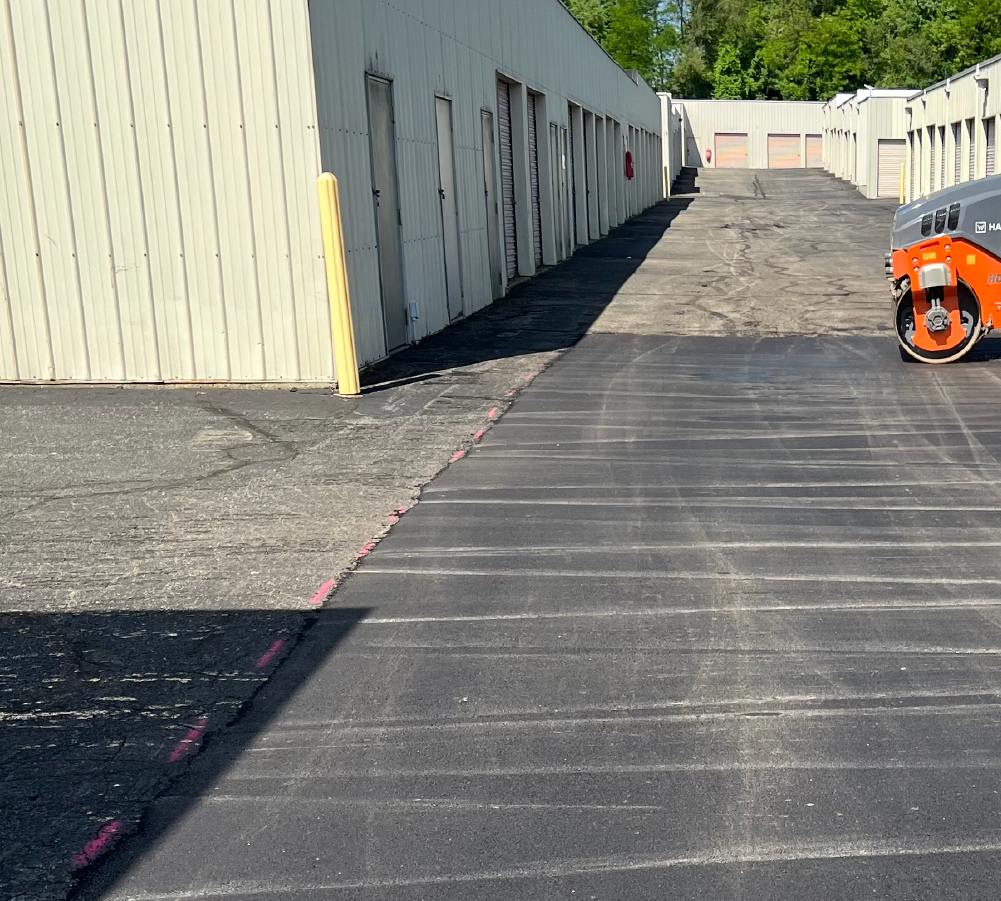 Sealcoated asphalt drive lane running alongside a commercial storage building