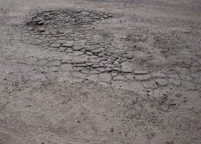 Weathered, deteriorating asphalt with widespread surface cracking