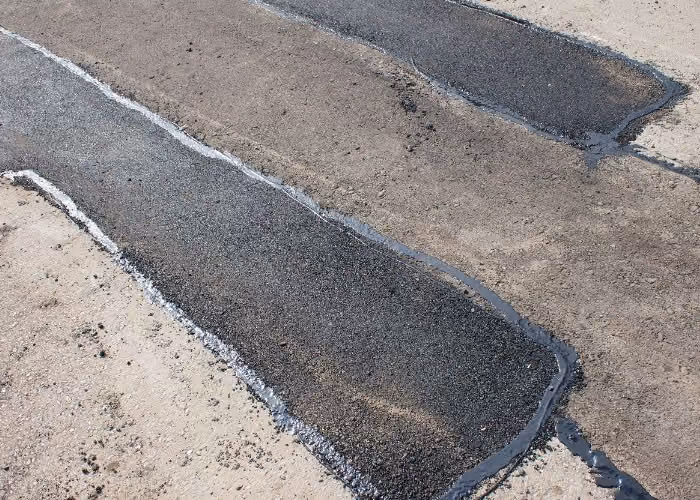 Long crack running through an aging asphalt surface