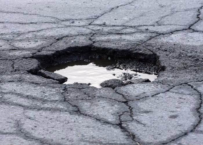 Pothole in a damaged asphalt parking lot