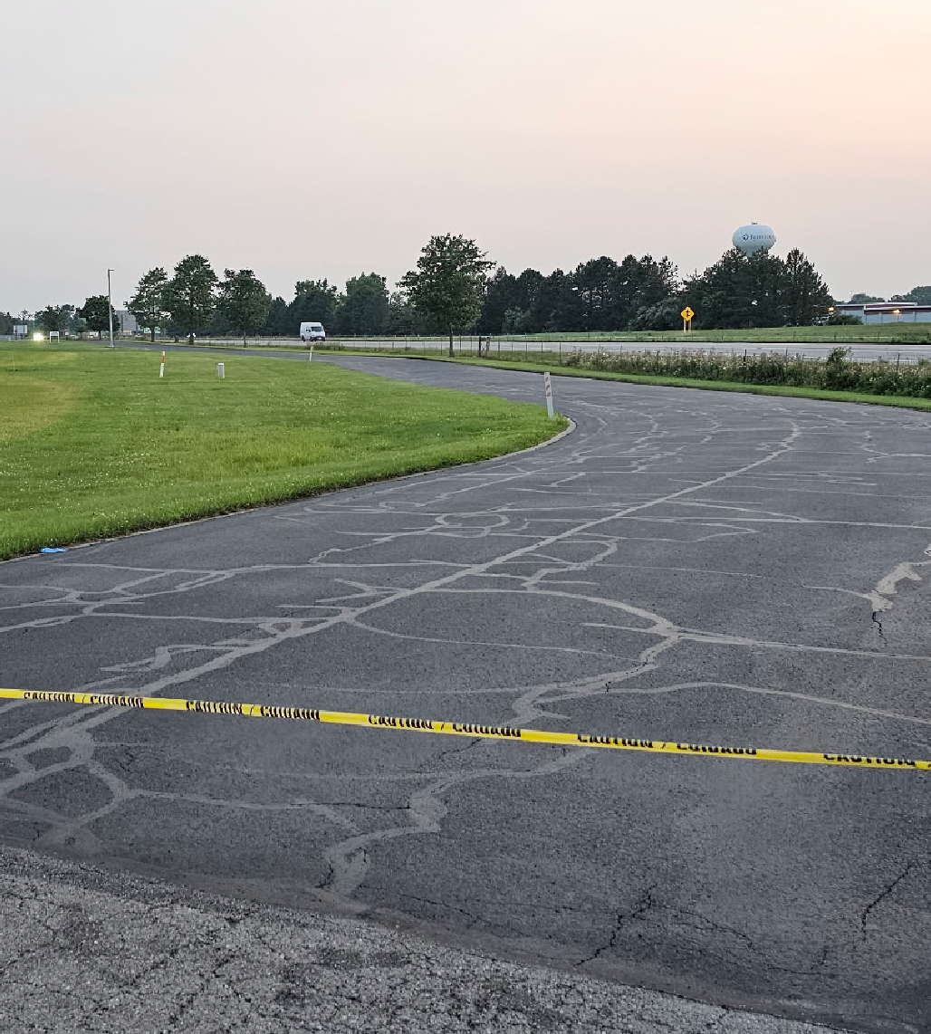Residential driveway with crack sealant applied across cracked asphalt