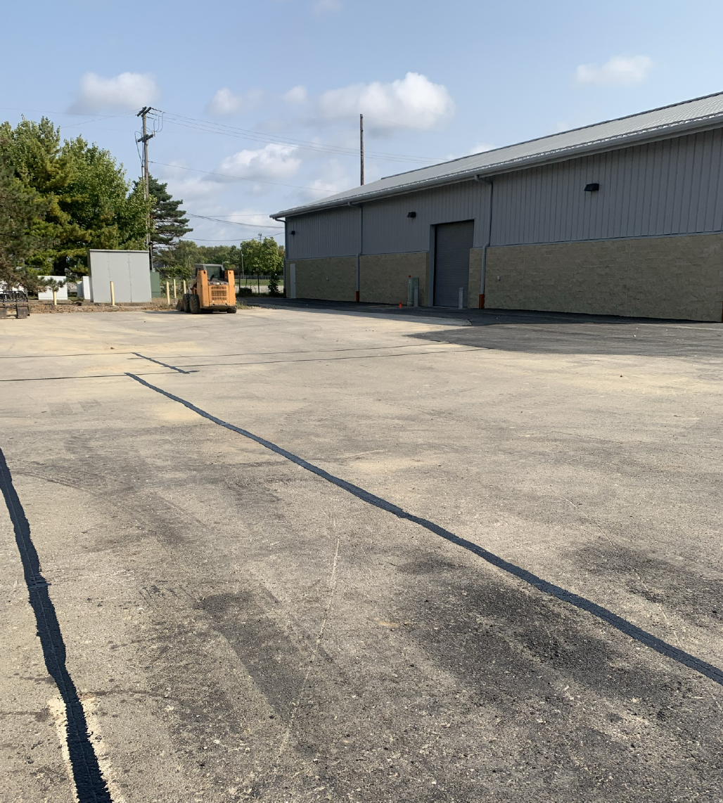 Sealed crack running across an industrial warehouse parking lot