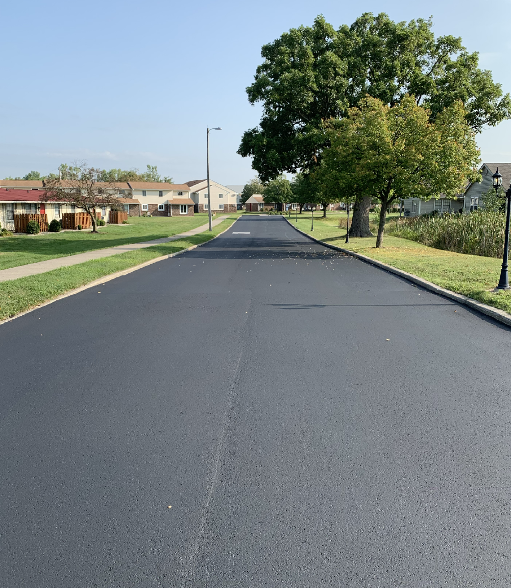 Freshly seal coated asphalt drive lane through a residential community