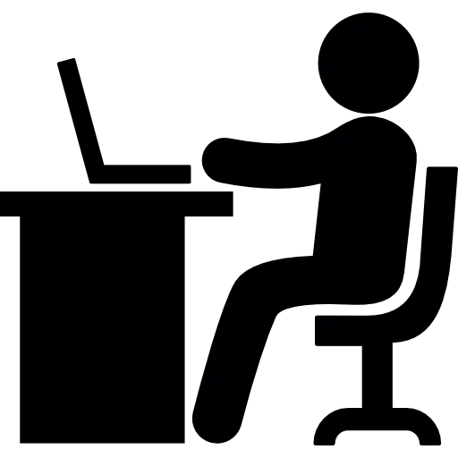 Silhouette of a person sitting at a desk using a laptop.