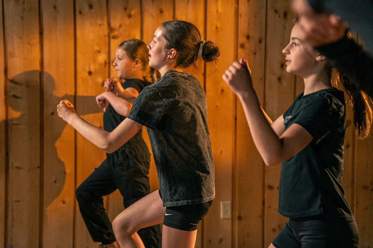 Élèves en pleine action, effectuant des mouvements de danse dans un environnement motivant et dynamique.