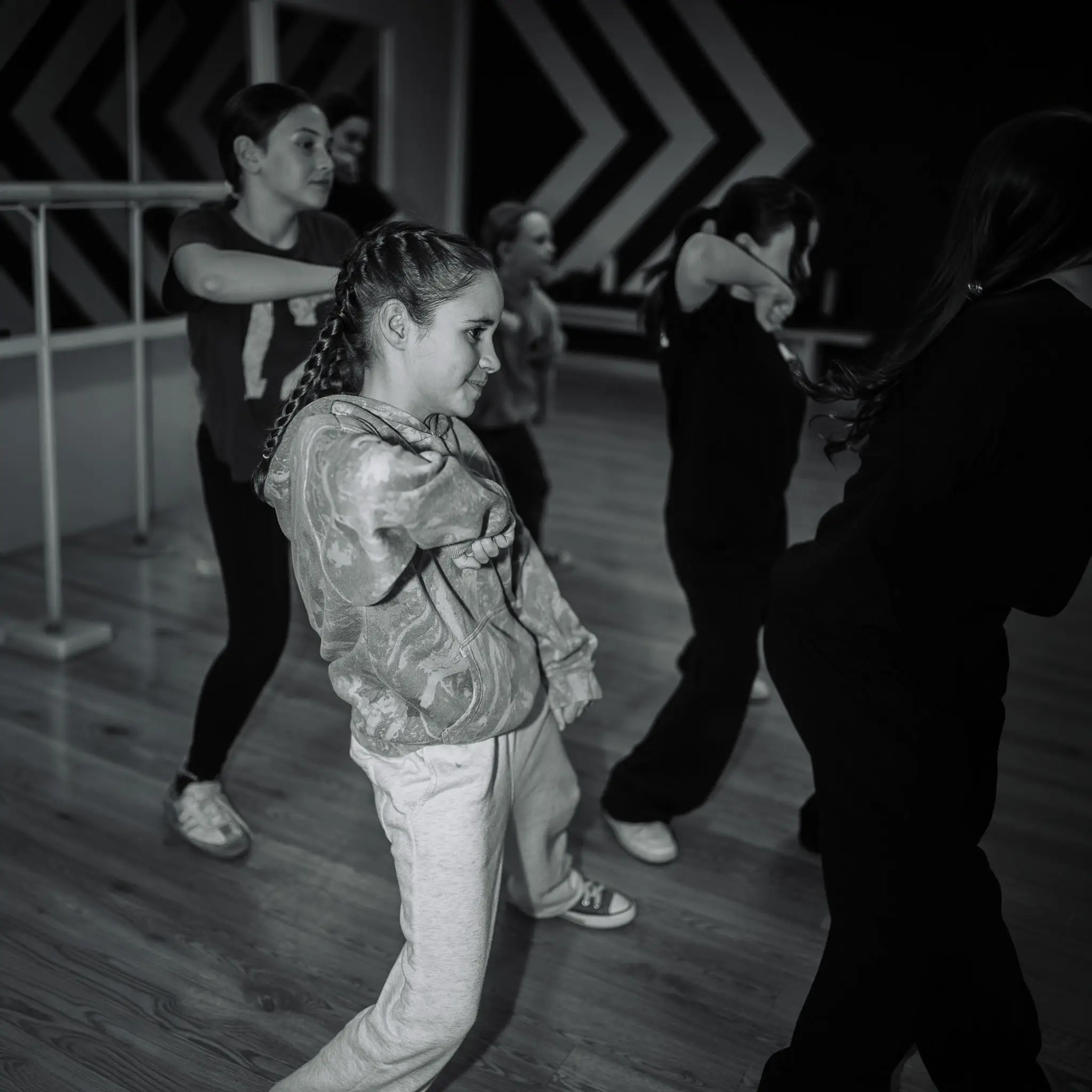 Jeune danseuse de troupe qui répète dans un studio à l'ambiance tamisée