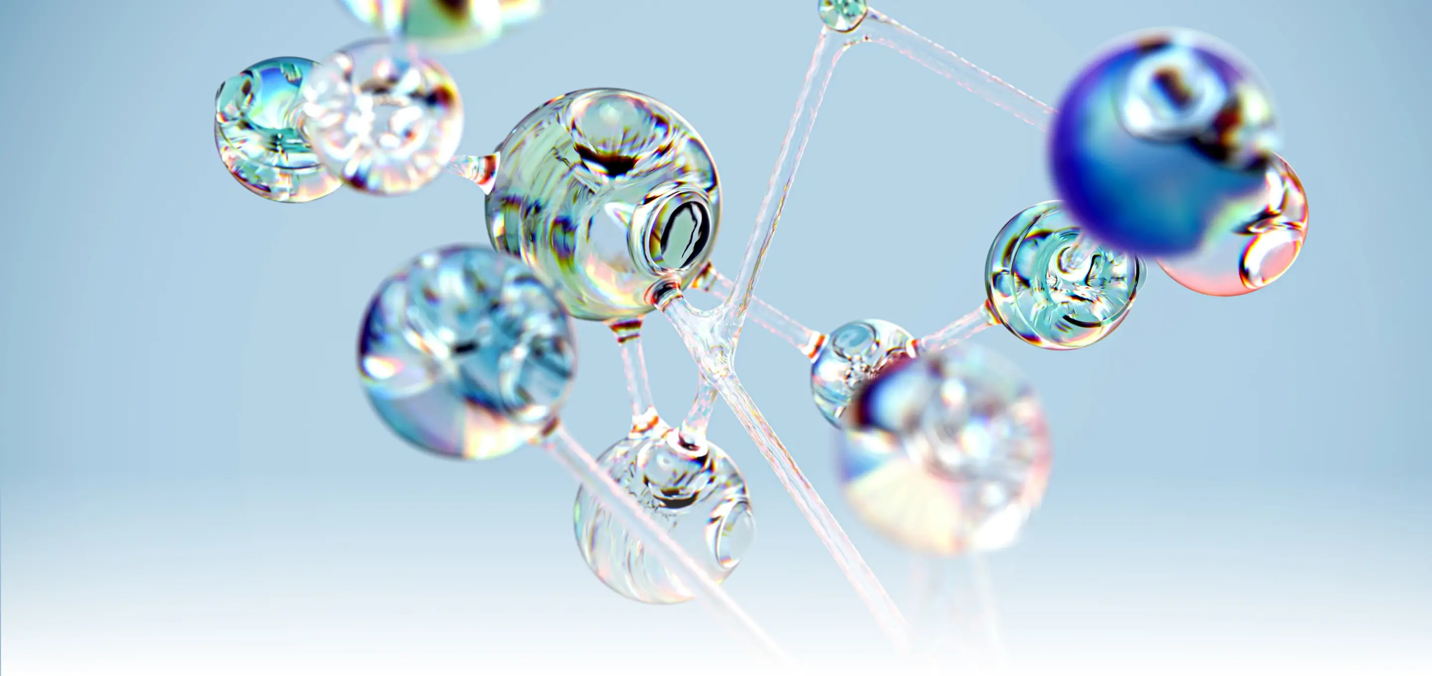 Close-up of transparent molecular structure with connected glassy spheres against a light blue background.