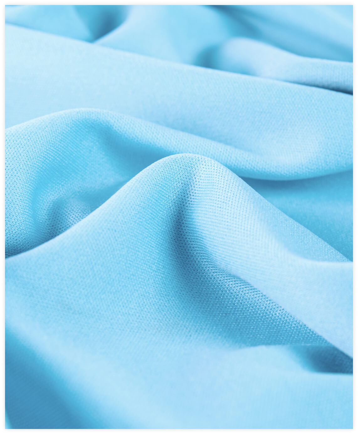 Close-up of soft, smooth blue fabric with gentle folds and texture.