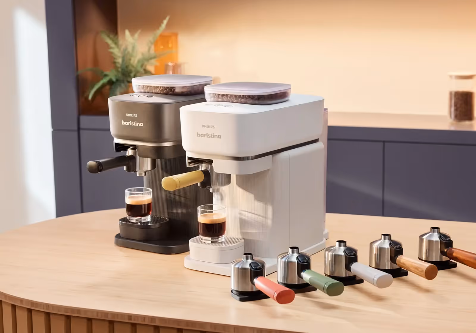 Two Philips Baristina espresso machines with espresso shots and six colored portafilters on a wooden table.