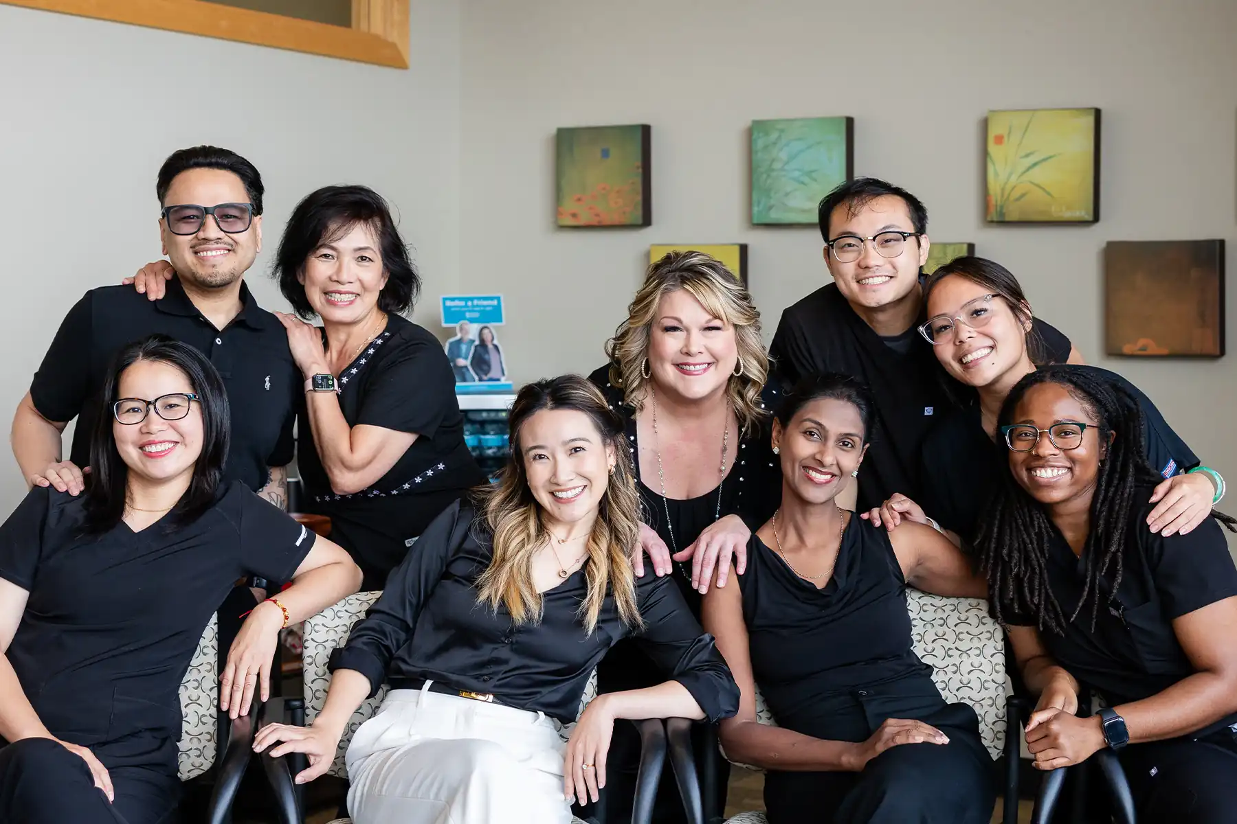 The Redmond Way Dentistry Team all in the lobby leaning together and smiling.