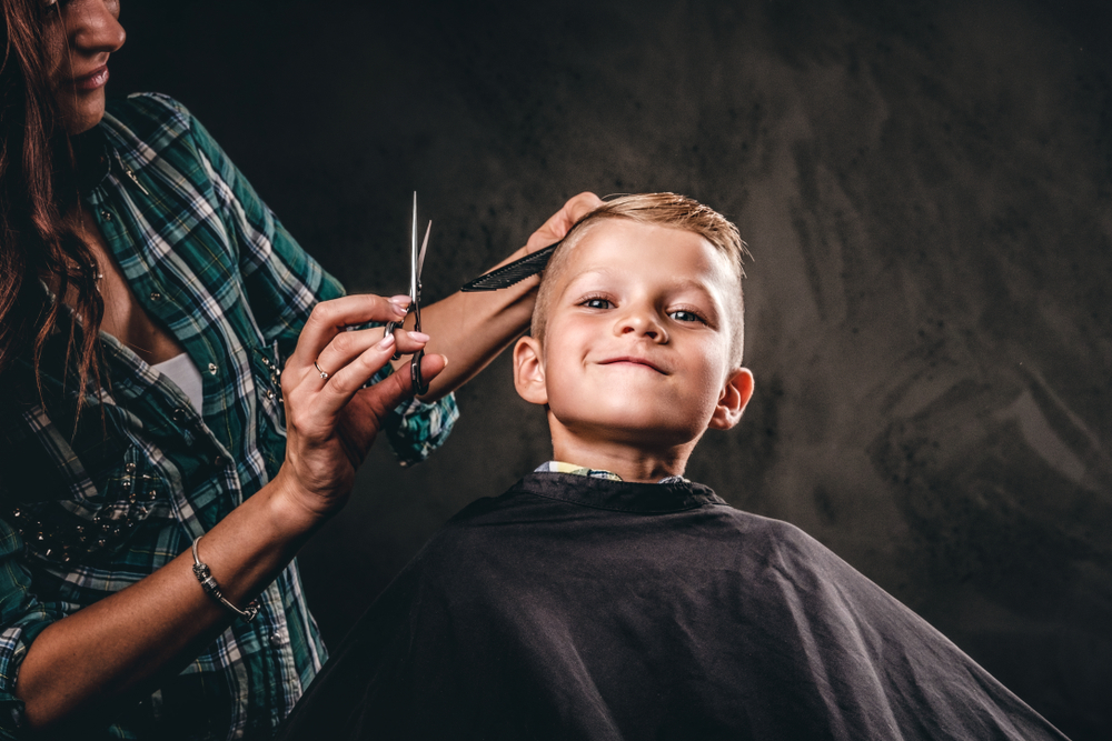 Kinderkapper knipt het haar van een kind in Rockanje