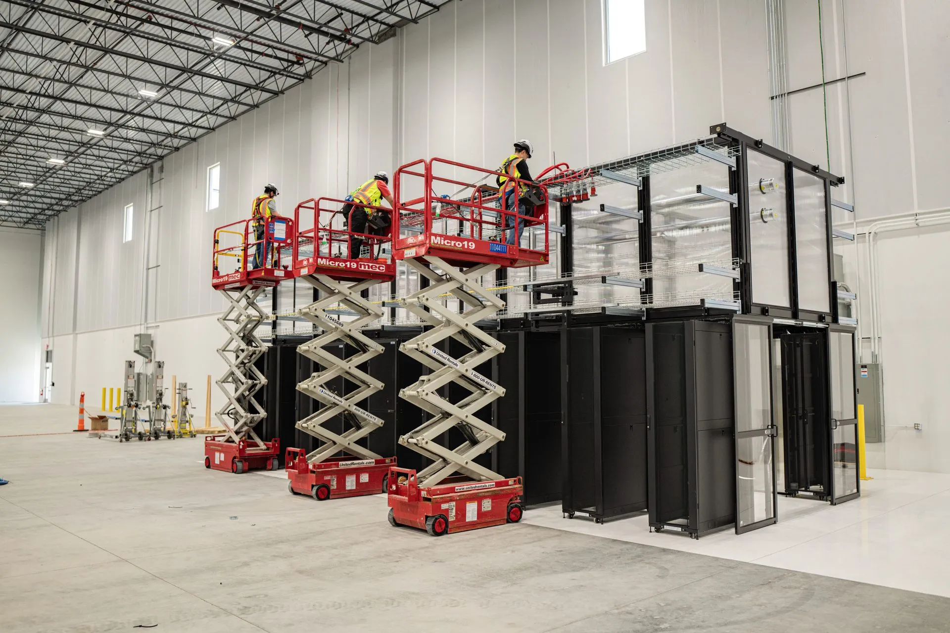 Crews on scissor lifts installing overhead electrical infrastructure