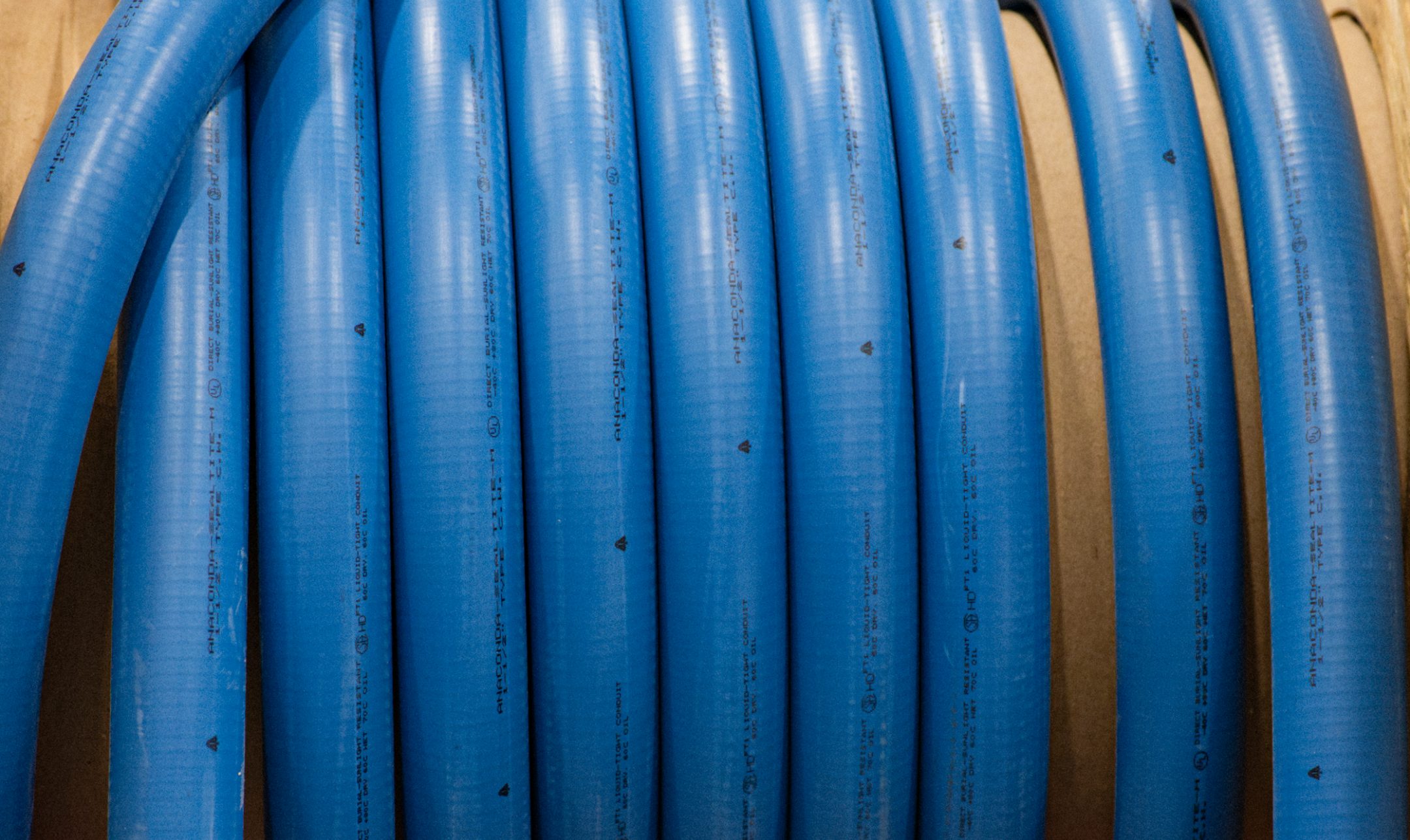 Coiled blue conduit on a cable reel