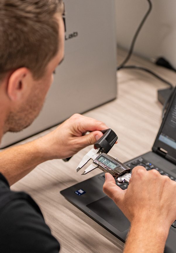 Engineer measuring a component with digital calipers