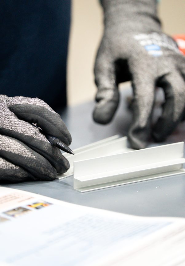 Gloved hands checking an aluminium profile