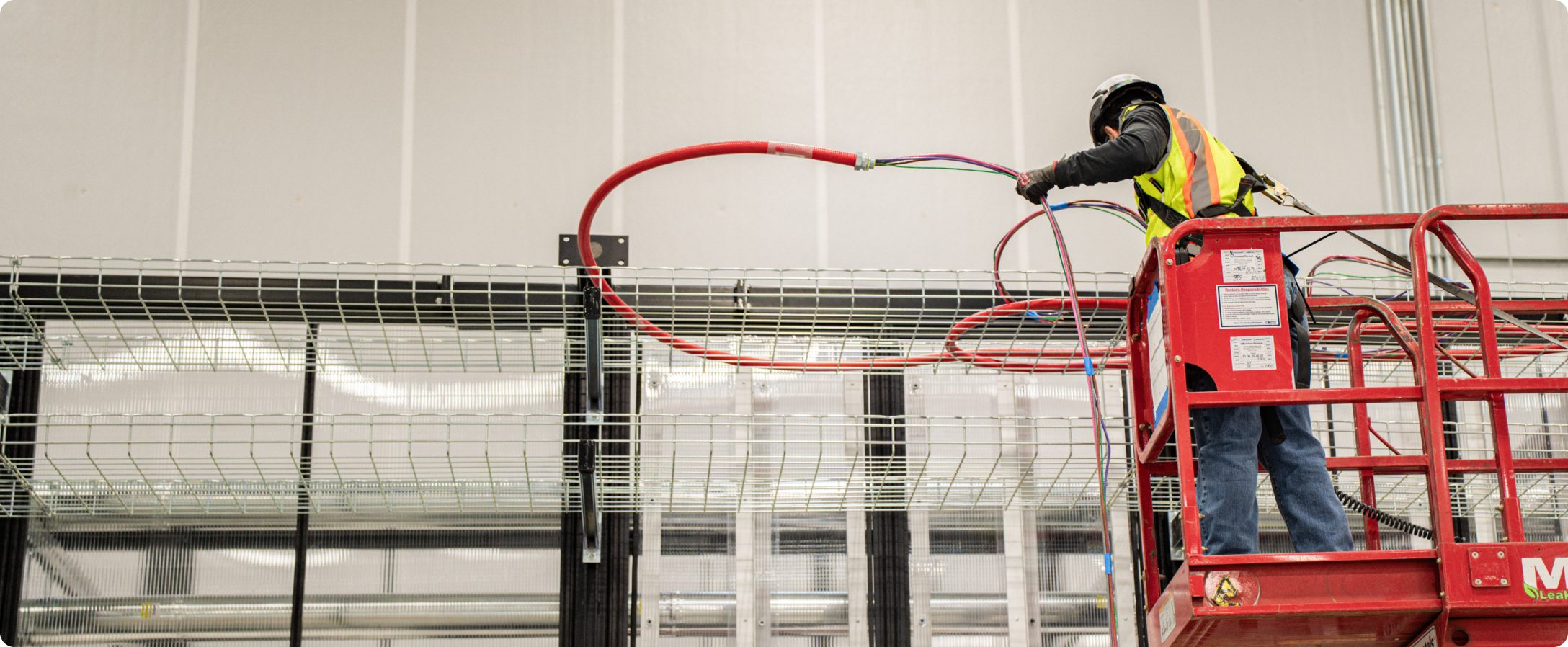 Accelevation electricians installing overhead infrastructure in a data hall