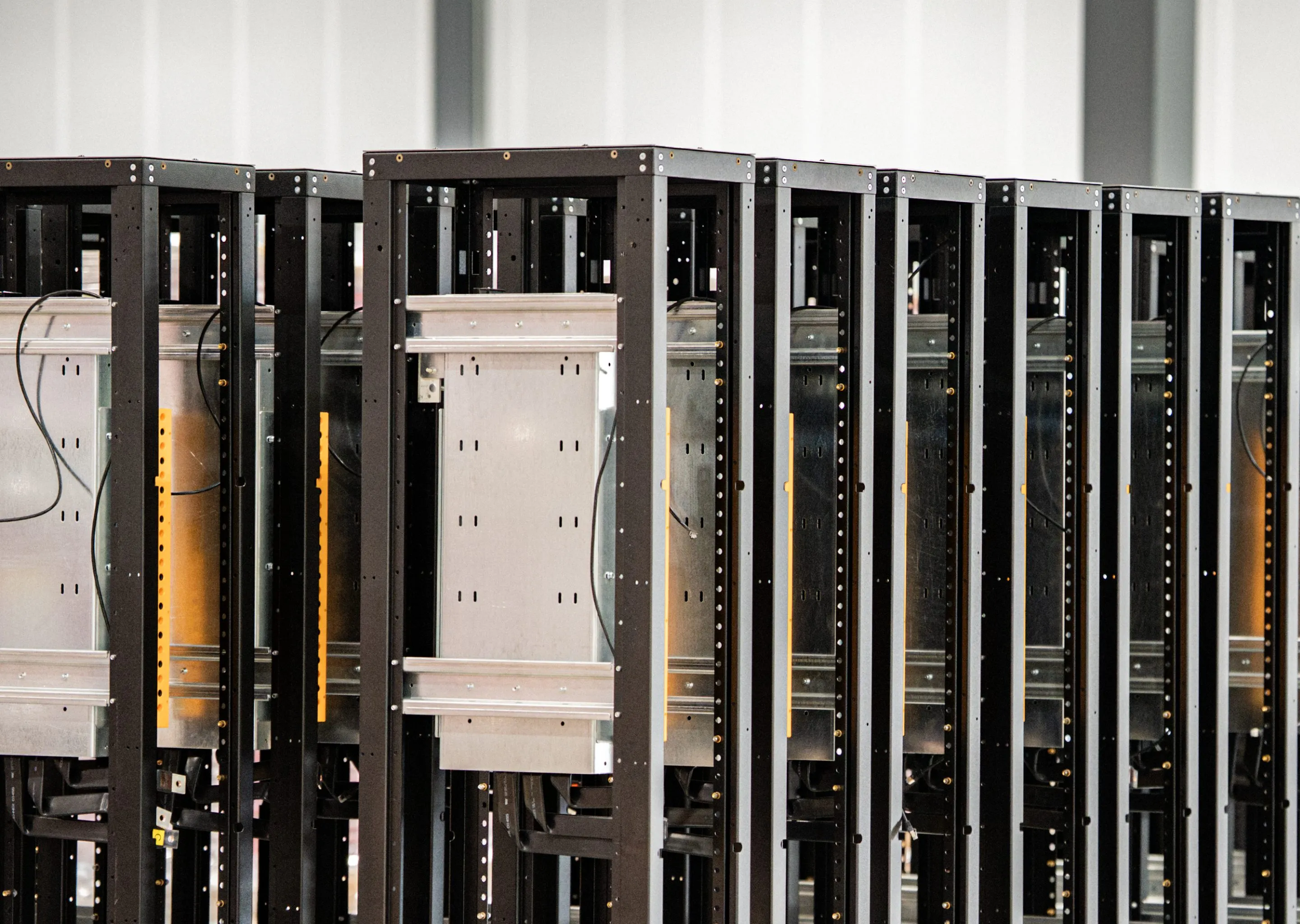 A row of black power distribution cabinets on the Accelevation production floor