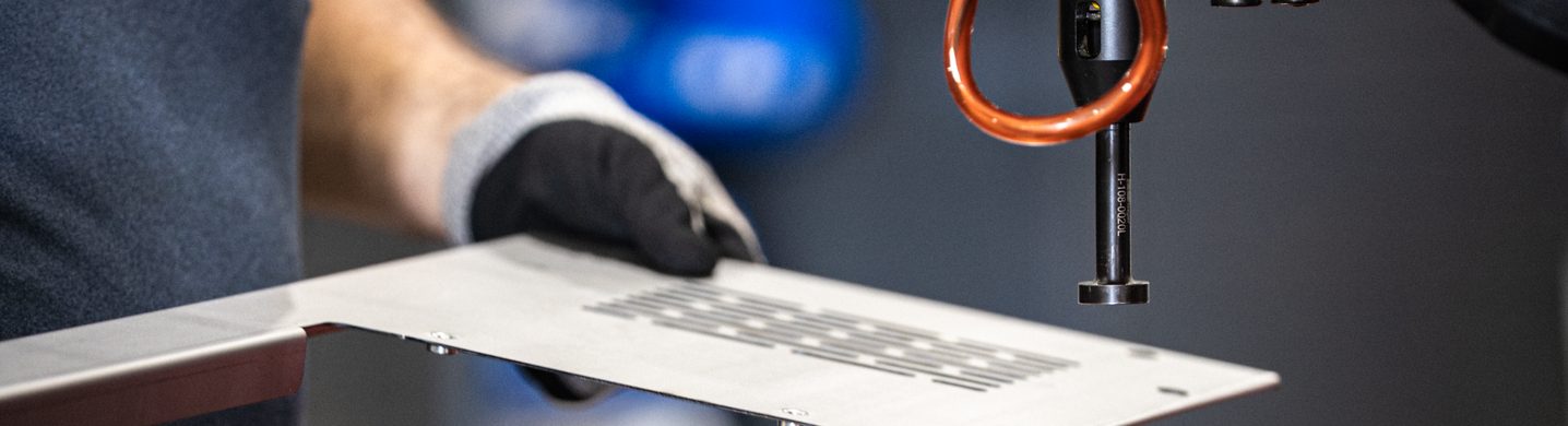 Gloved hands assembling an aluminium component with cabling