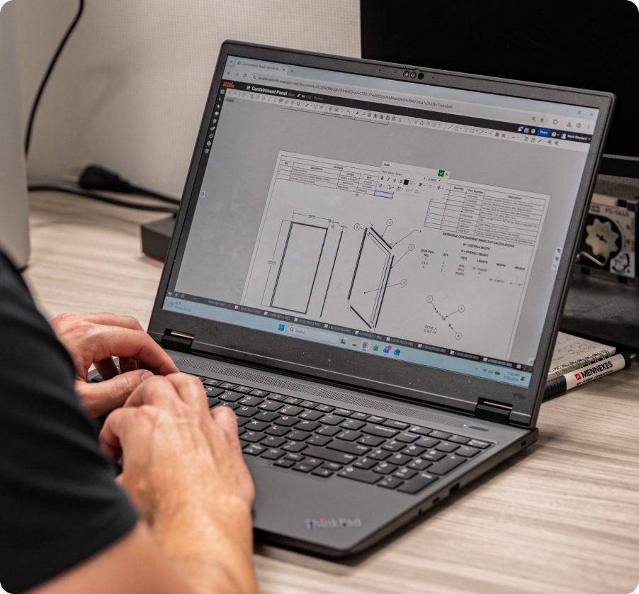 Engineer reviewing a component drawing in CAD on a laptop.