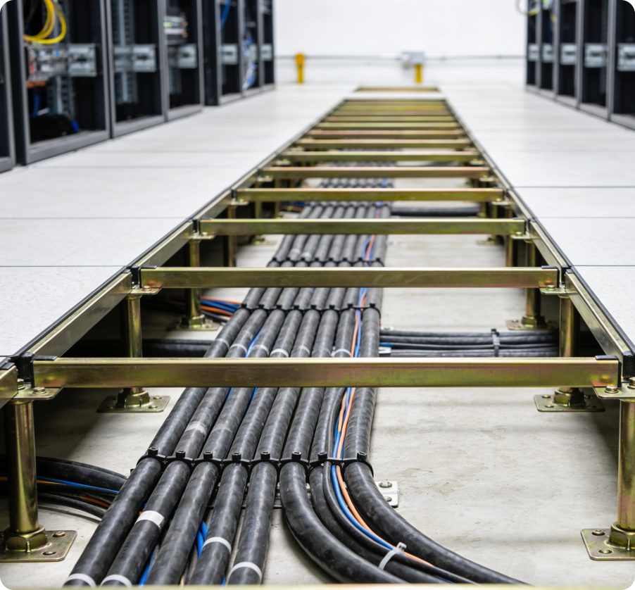 Under-floor cable tray carrying power and data runs during decommissioning.