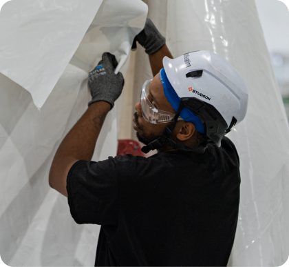 Installer fitting containment panels in a data hall.