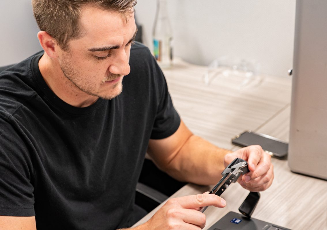 Engineer measuring a component with calipers at a design workstation
