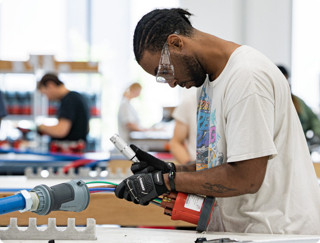 A team member using a power tool during hands-on training