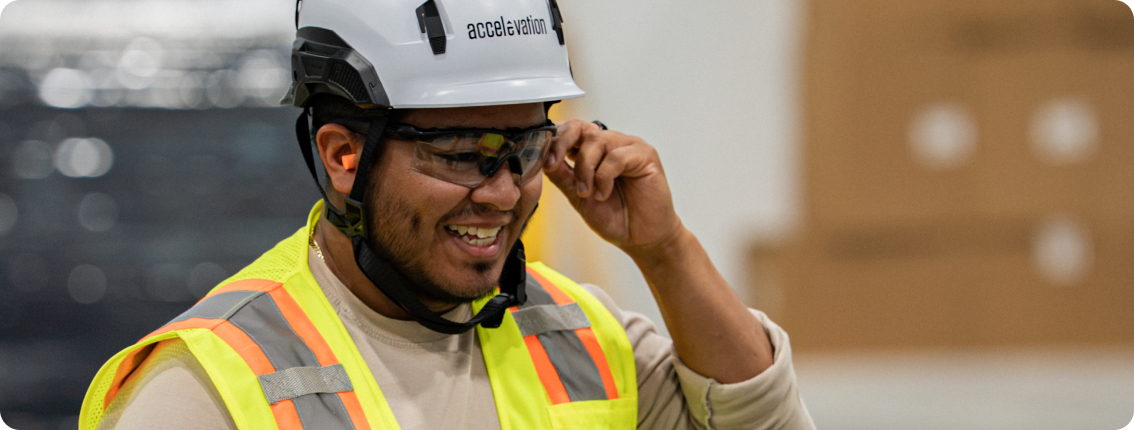 A team member in a hard hat and hi-vis vest on site