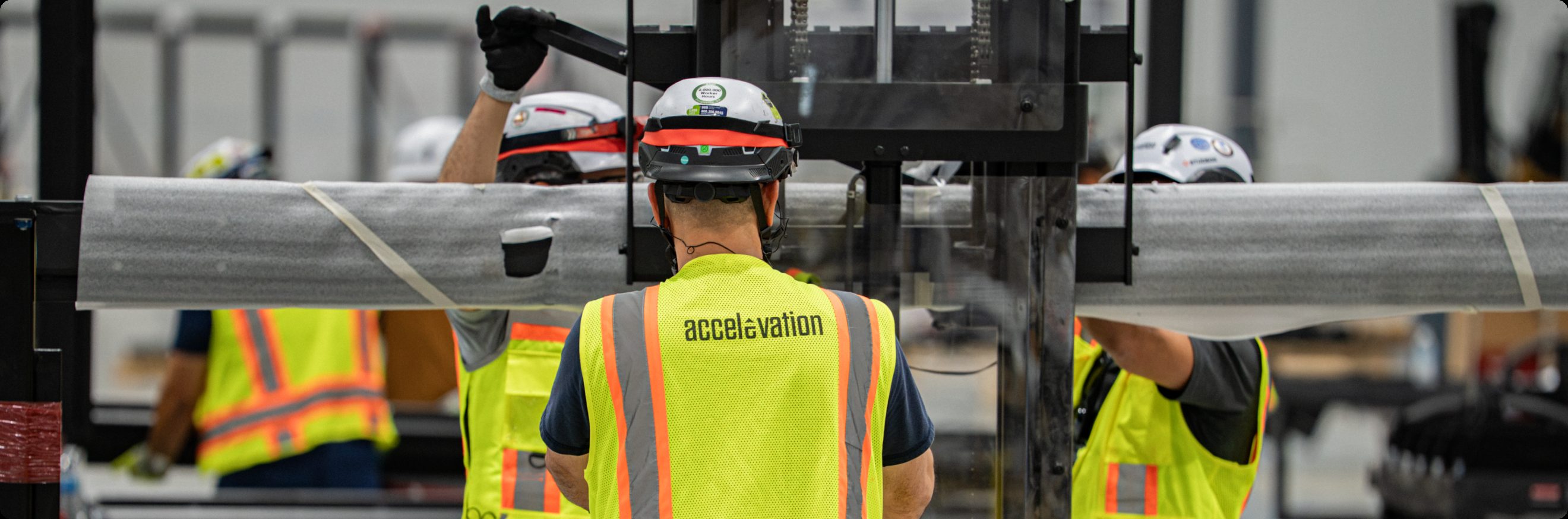 Accelevation field crew carrying a structural steel member through the manufacturing facility.