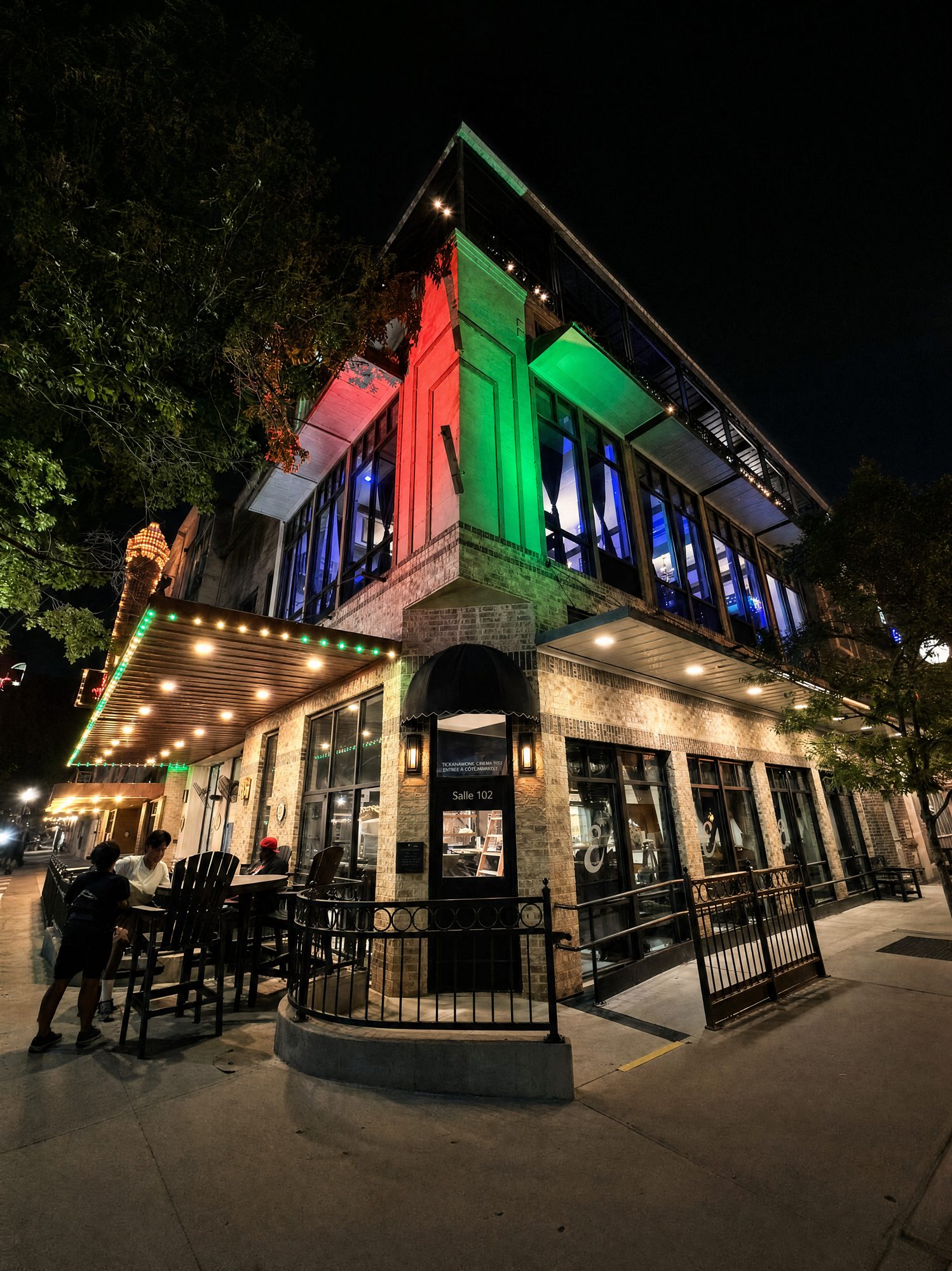 Encore building exterior at night, lit in red and green