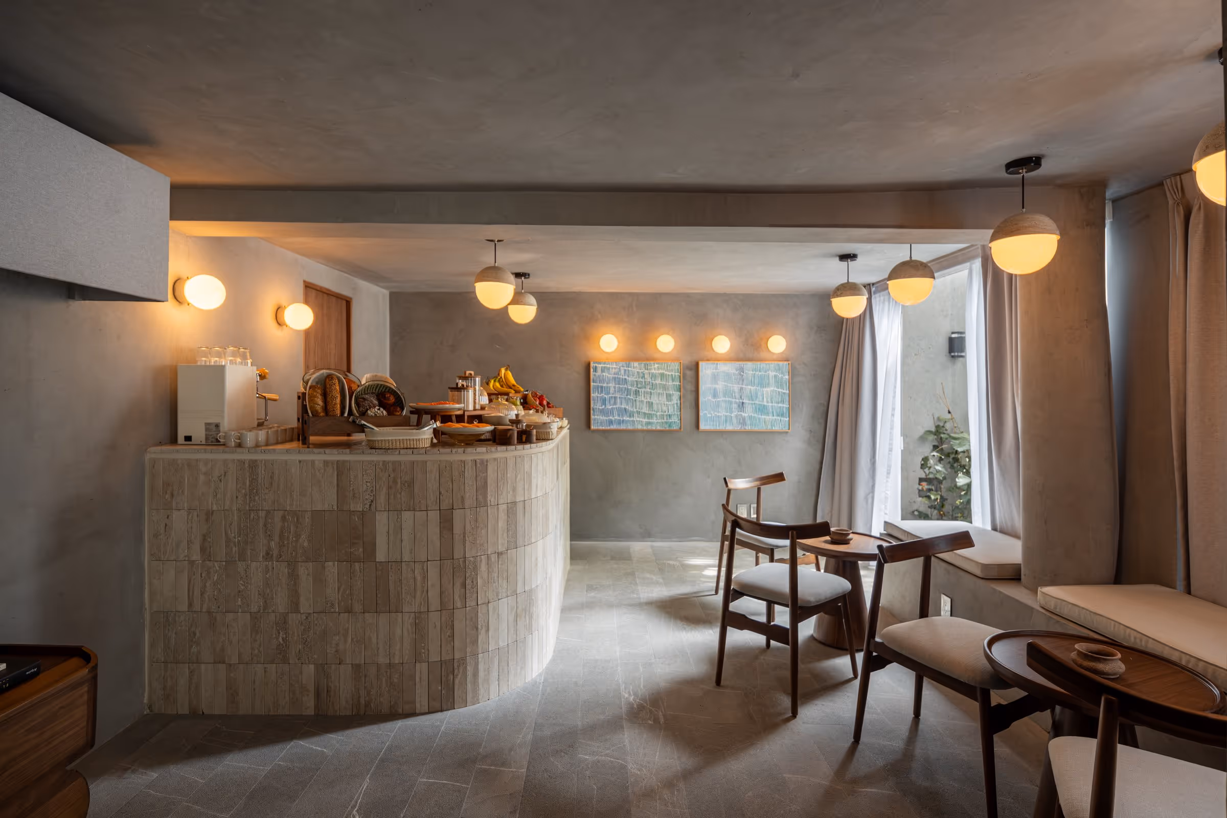 Cozy breakfast nook with a curved tiled counter, chairs, cushioned benches, and warm lighting.