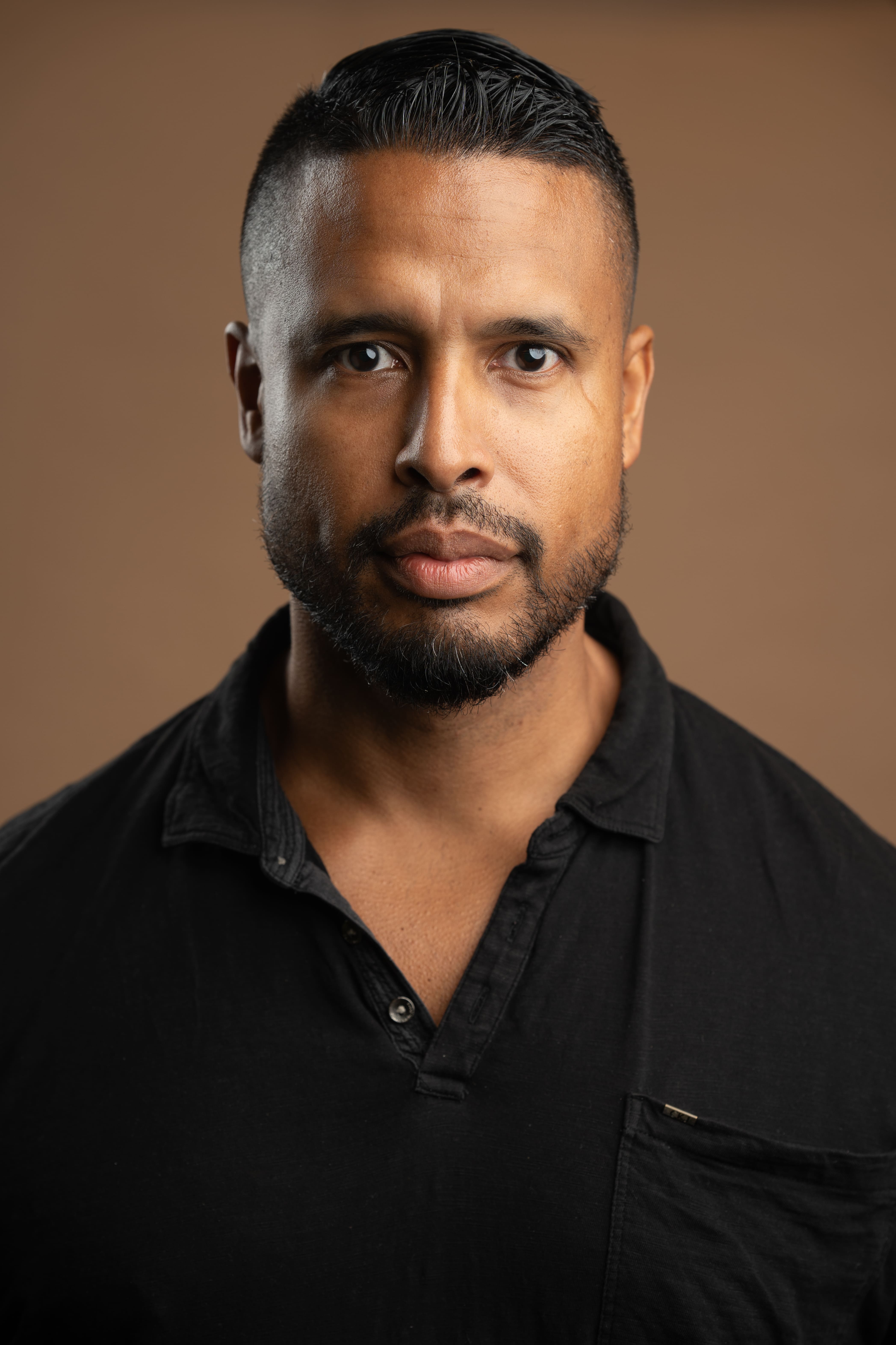 Staff headshot of M. Lopez in black shirt