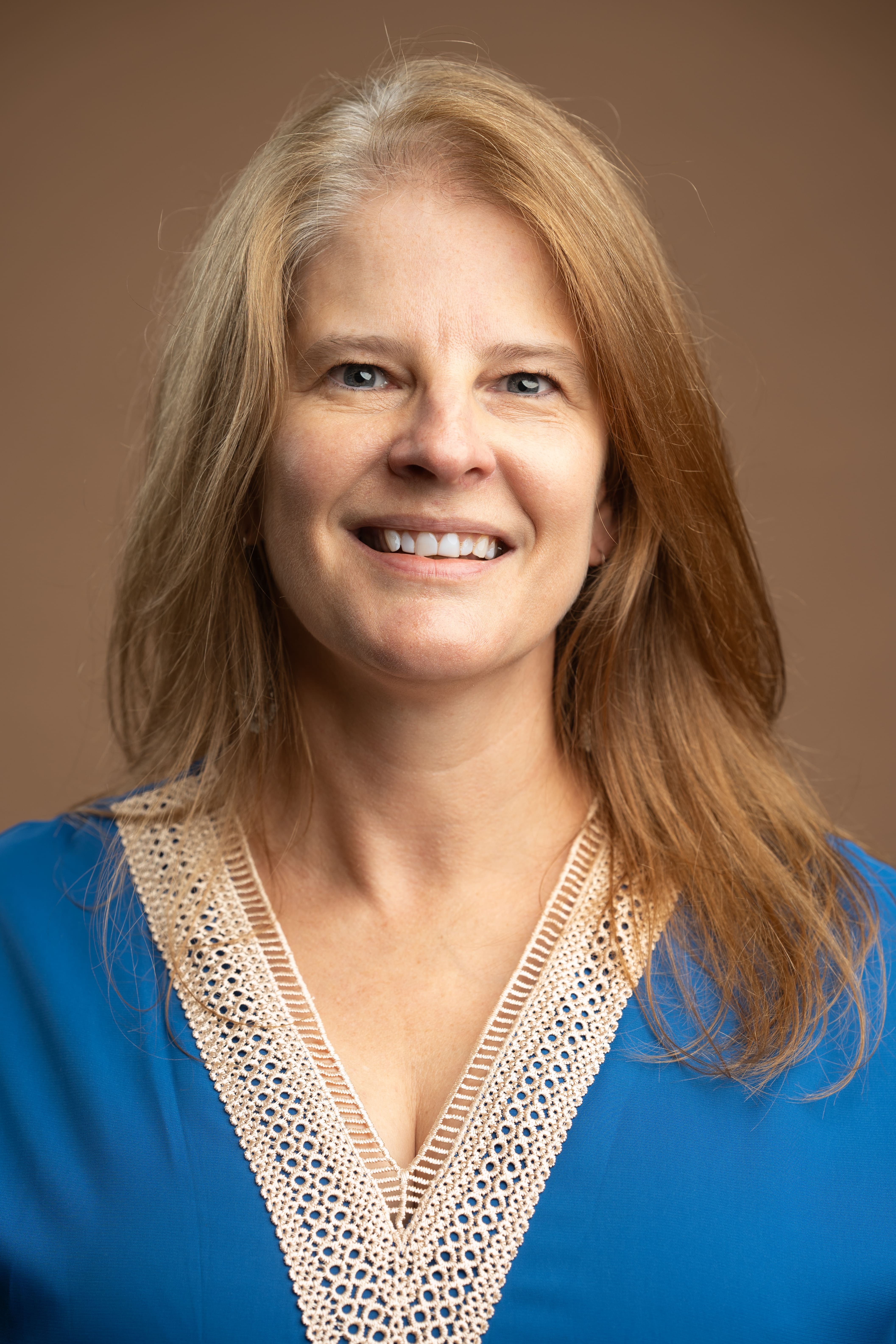 Staff headshot of C Hammond smiling in blue top