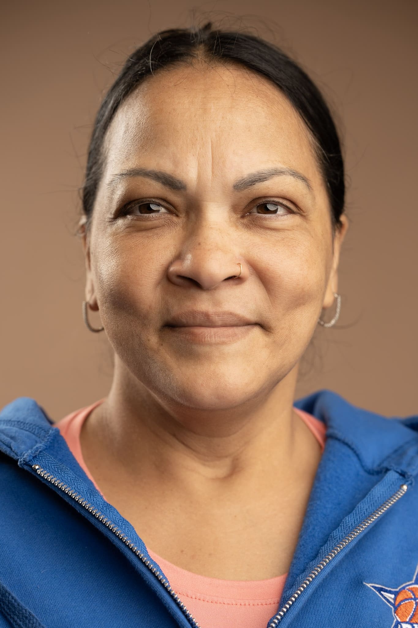 Staff portrait of Brumatie Rampersad smiling in blue hoodie