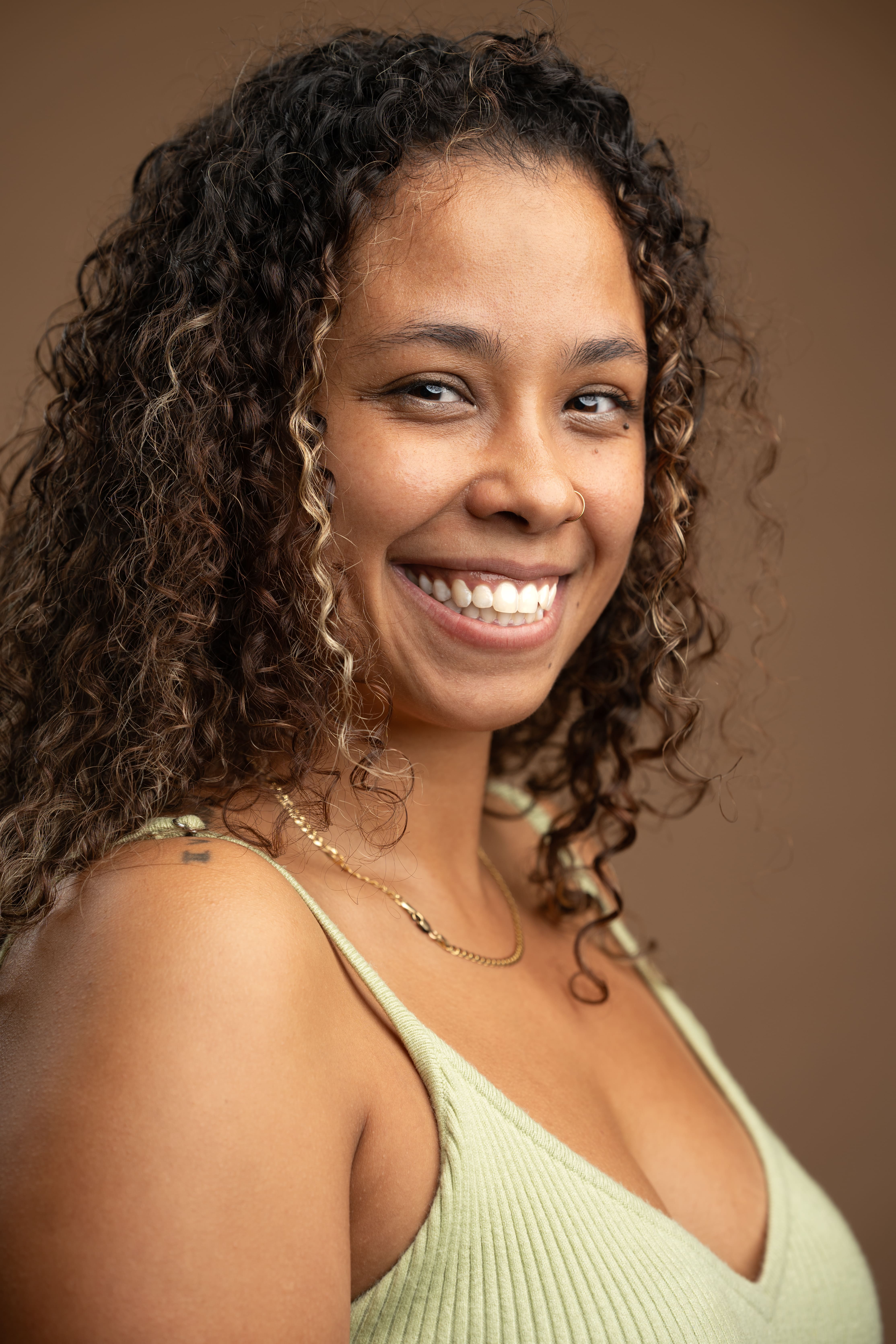 Staff headshot of B. Pinero smiling warmly at camera