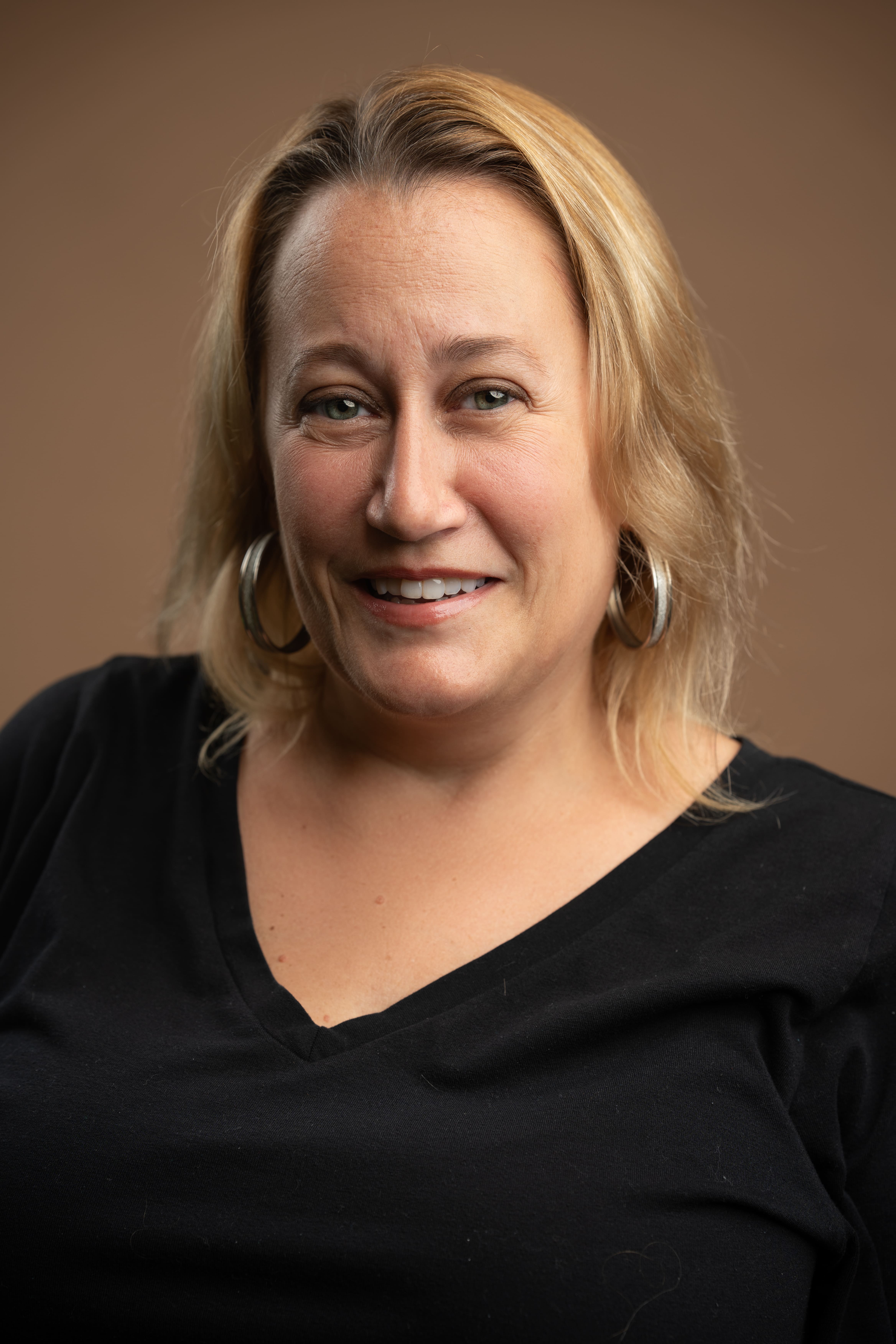 Staff headshot of J. Iurato smiling in black top
