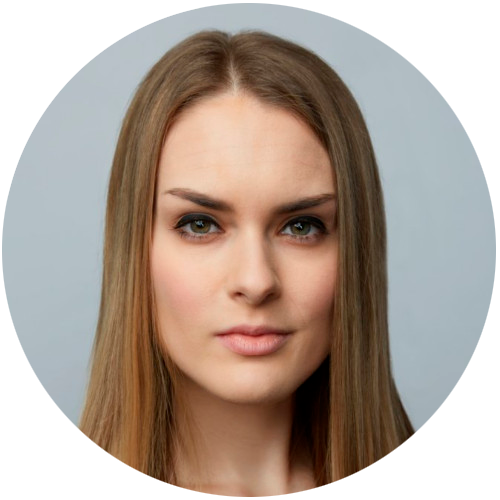 Close-up of a woman with long straight brown hair and a neutral expression on a gray background.