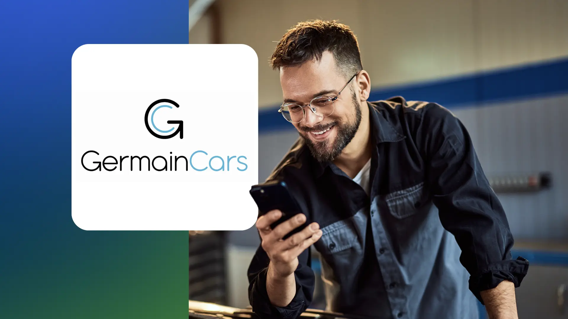 Smiling man wearing glasses and a mechanic shirt looks at his phone in a workshop with GermainCars logo.