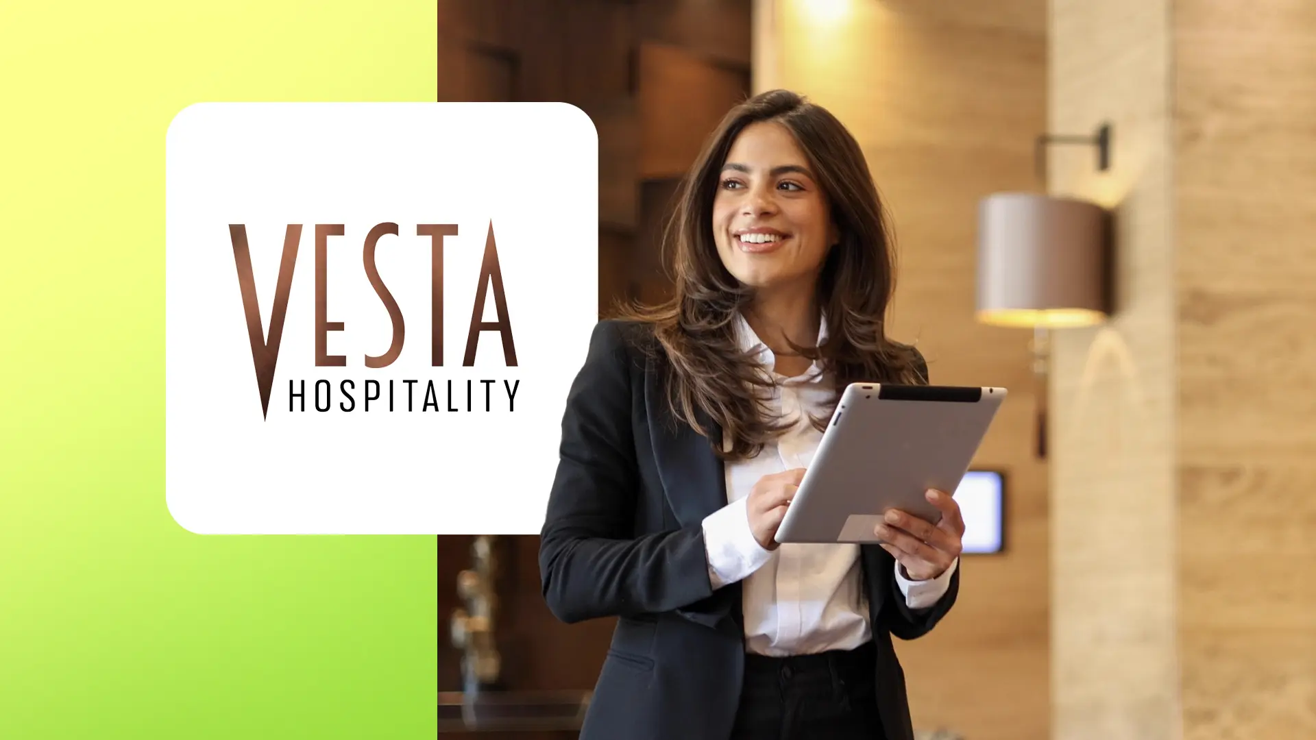Smiling woman in business attire holding a tablet with Vesta Hospitality logo on a green background.