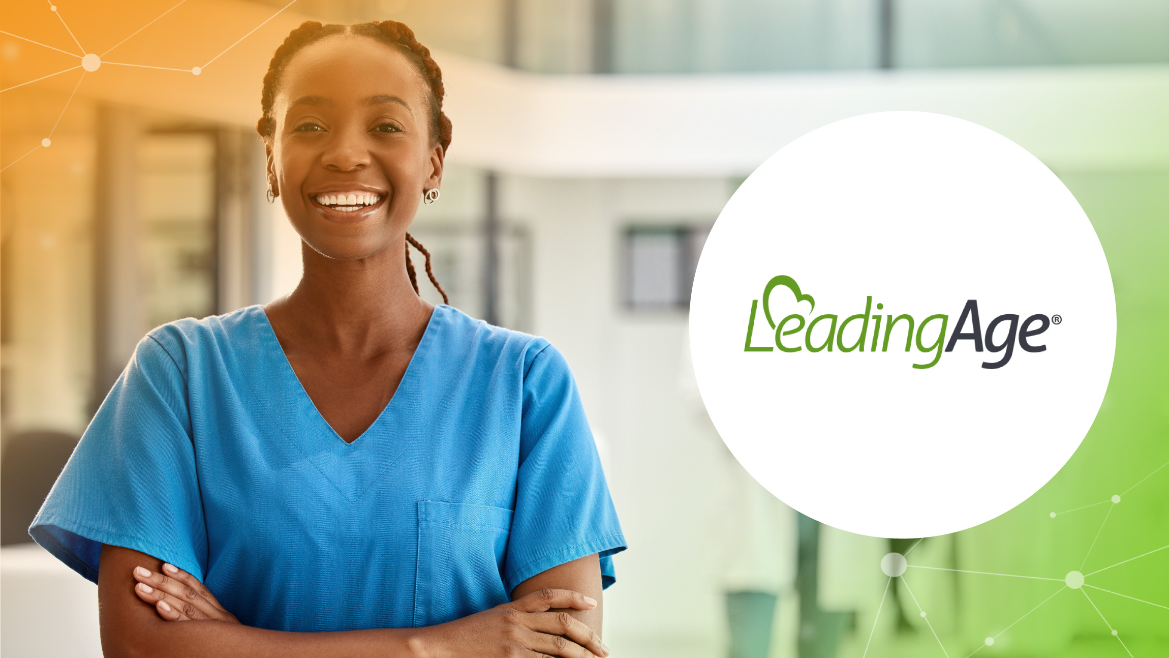 Smiling female healthcare worker in blue scrubs stands with arms crossed next to LeadingAge logo.