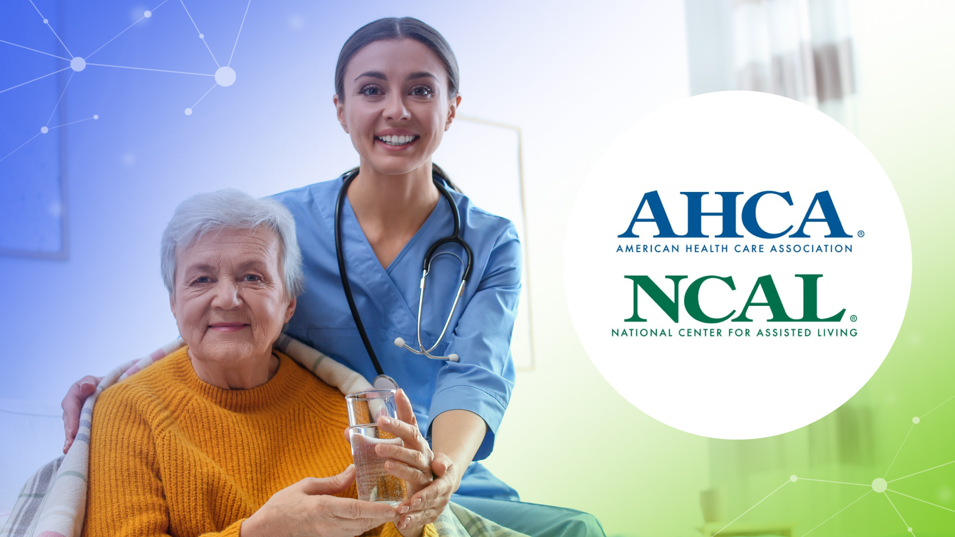 Smiling nurse in blue scrubs helping an elderly woman in a yellow sweater hold a glass of water.