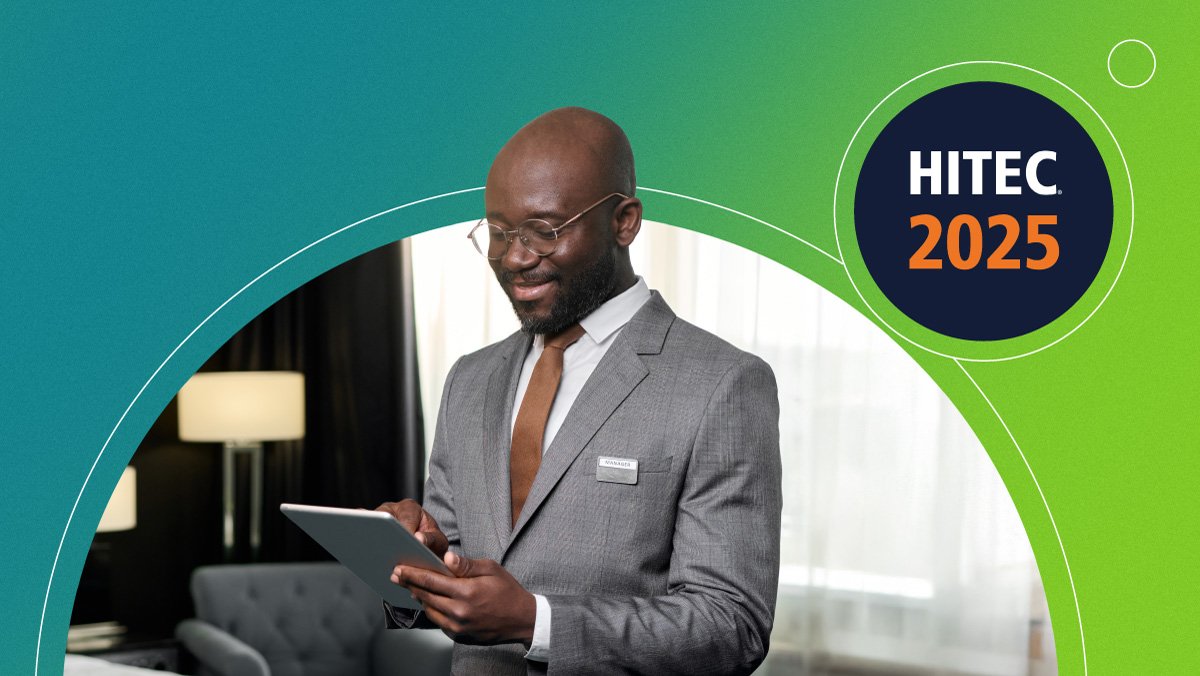 Smiling man in gray suit and brown tie using tablet with HITEC 2025 logo on green-blue background.