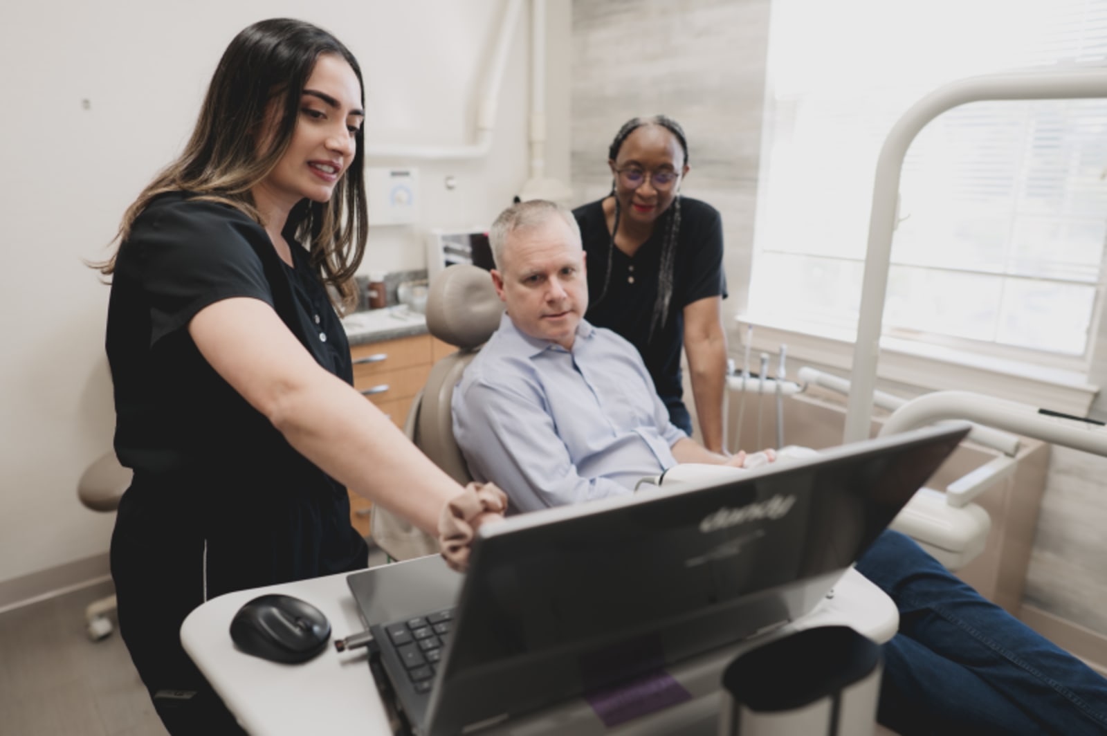 Dentist discussing treatment options with a patient in an exam room