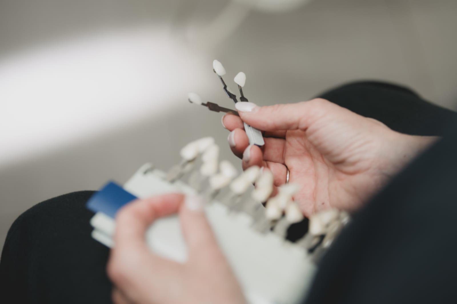 Close-up of tooth shade guide samples being discussed during dental consultation